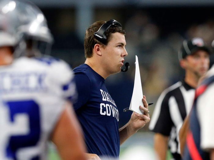 Dallas Cowboys offensive coordinator Kellen Moore runs the offense on the sideline during the first quarter of their preseason game against the Tampa Bay Buccaneers at AT&T Stadium in Arlington, Texas, Thursday, August 29, 2019.