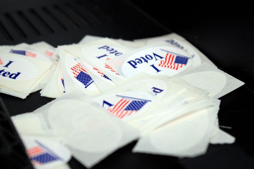 Voter stickers sit in a pile near a ballot machine at an early voting site.