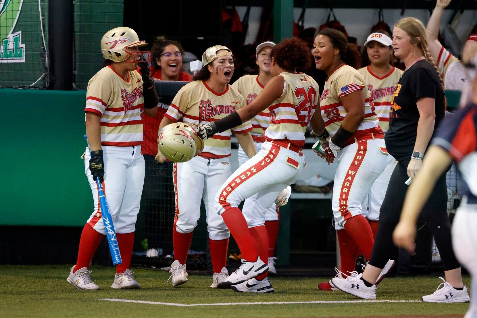 South Grand Prairie’s Jasmyn Lloyd (20) s congratulated by teammates after she drove in...