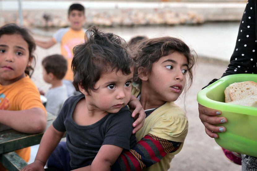 Refugee children look at food at a camp on the island of Souda in Greece, a nation that is...