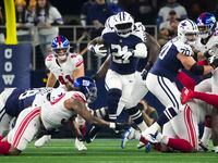 Dallas Cowboys running back Ezekiel Elliott (21) breaks through the New York Giants defends...