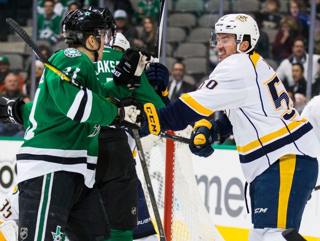 Dallas Stars left wing Antoine Roussel (21) gets hit with a stick by Nashville Predators...