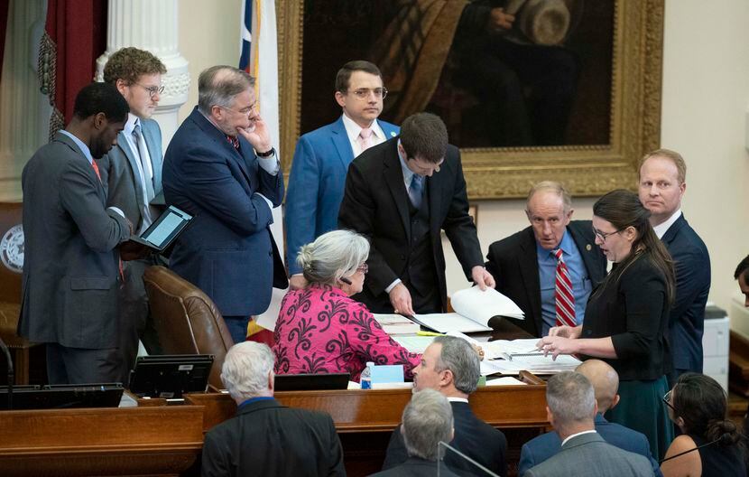 As State Rep. Briscoe Cain R-Deer Park, watches (in blue jacket), House members discuss a...