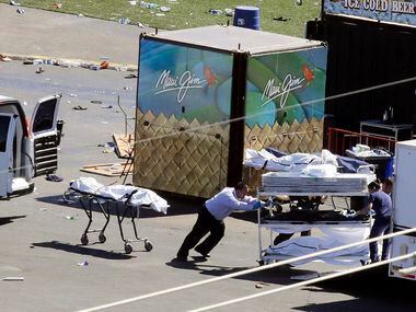 Investigators load bodies from the scene of a mass shooting at a music festival near the...