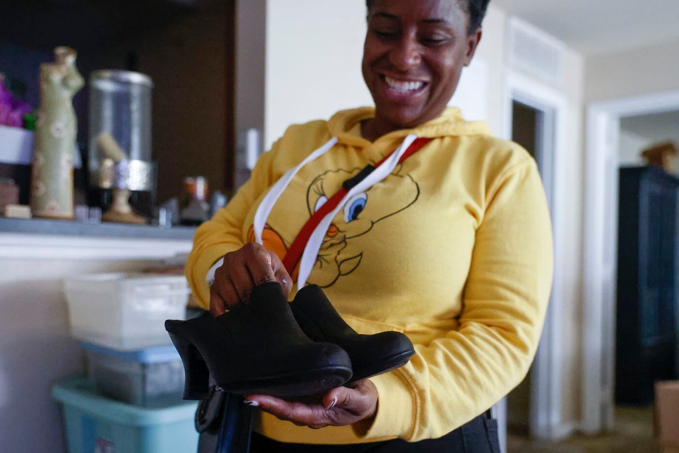 Home owner Latanya Benefield shows a pair of shoes of her late mother which she saved from...