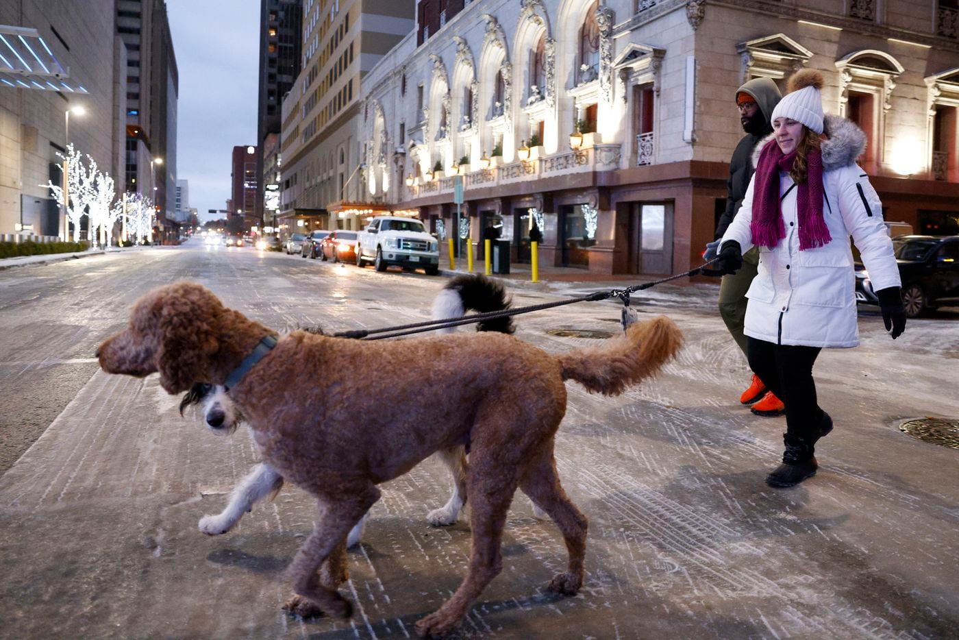 Elizabeth Hartman (right) walks her dogs Theo and Bea with Sterling Jordan across Commerce...