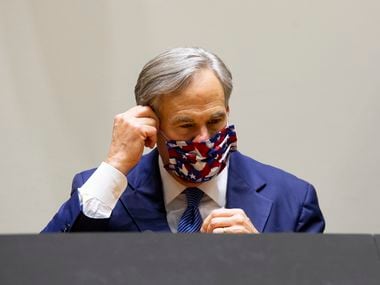 Governor Greg Abbott takes off his mask before leaving on Tuesday, April 2.