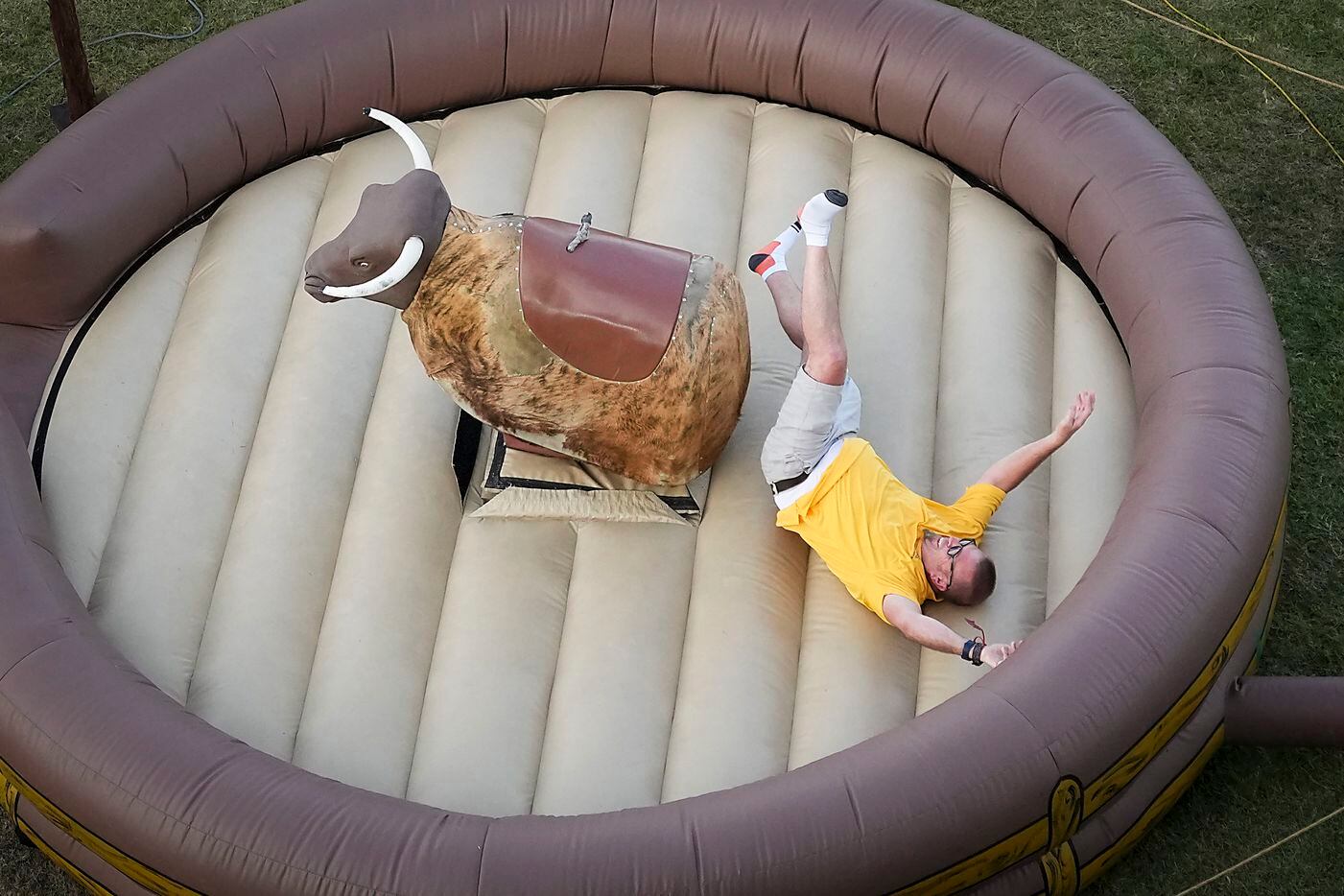 A participant is thrown from a mechanical bull during the Chili’s General Manager Conference...