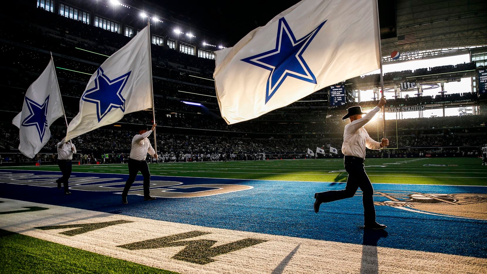 The Dallas Cowboys flag team flies through the end zone following a first half touchdown in...