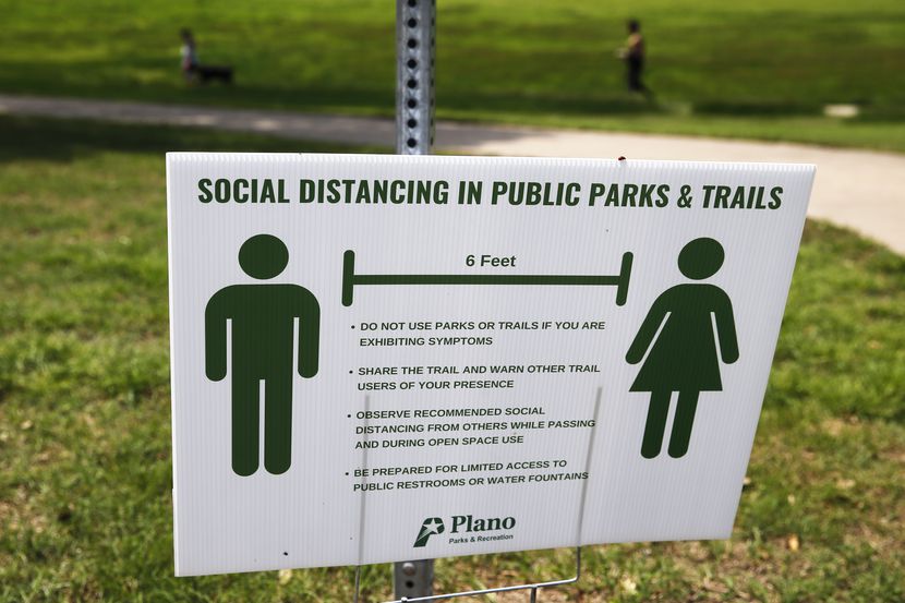 A sign displays social distancing practices at Bob Woodruff Park in Plano, Texas on Tuesday,...