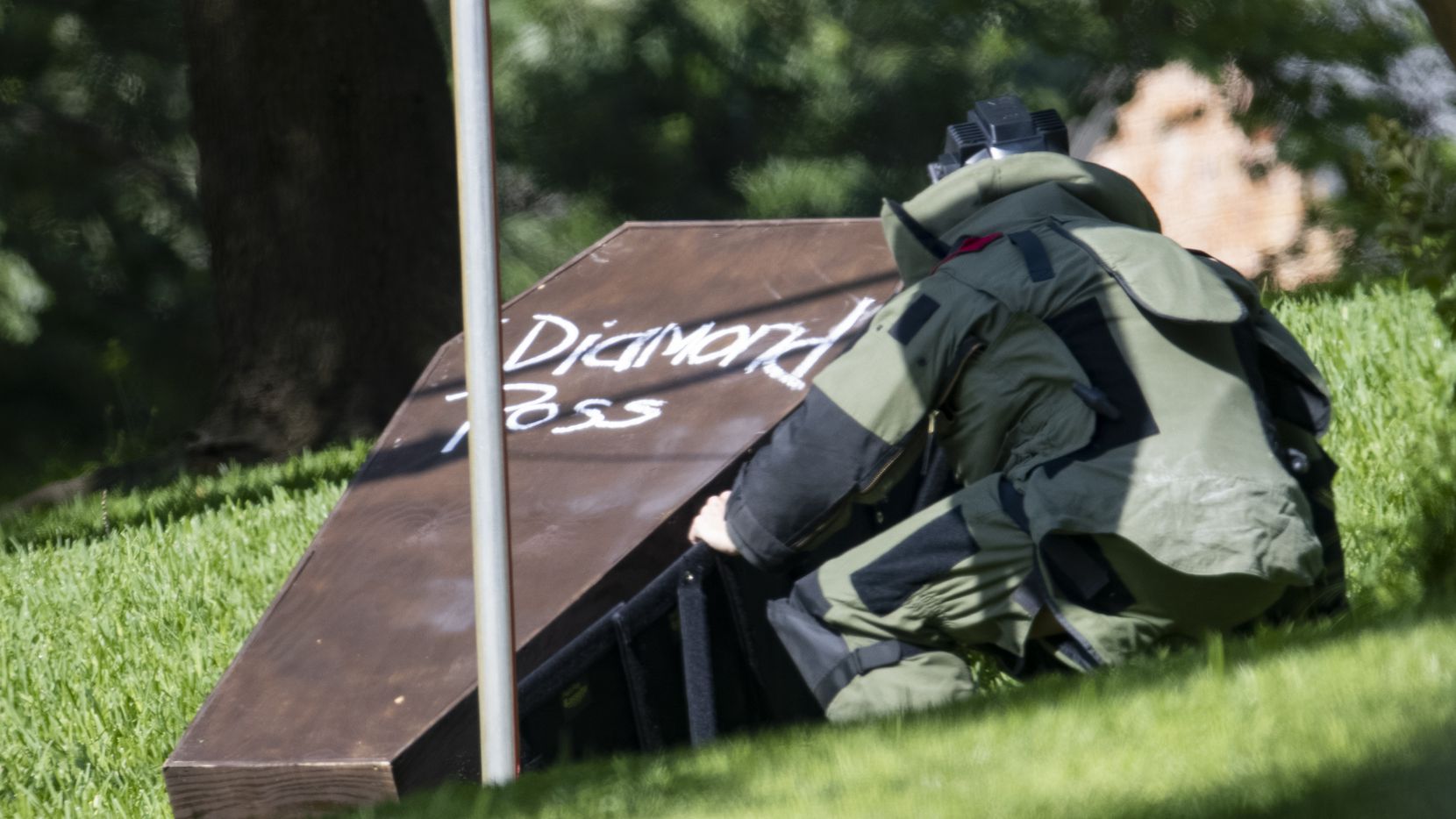 A bomb squad member investigates the coffin that was placed on Dallas County District Attorney John Creuzot's front lawn May 29, 2021.
