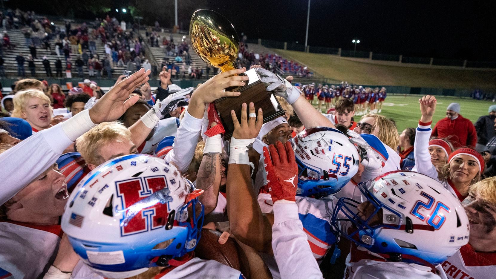 Midlothian Heritage players celebrate with the trophy after defeating Crandall 45-37 in an...