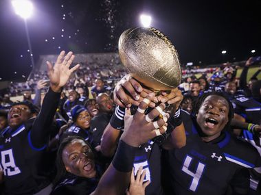 Mansfield Summit players celebrate with the game's trophy after beating Colleyville Heritage in the Class 5A Division I Region I Final on Friday December 3, 2021 in North Richland Hills, Texas.  (Smiley N. Pool / The Dallas Morning News)