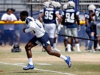 Dallas Cowboys wide receiver Michael Gallup (13) uses a resistance cord to work on his...
