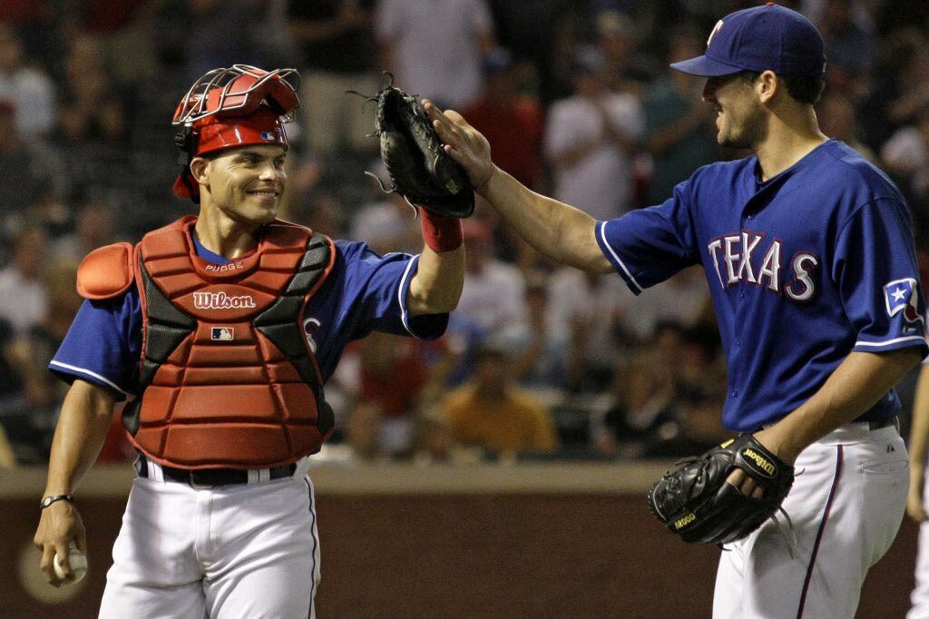Texas C Ivan Rodriguez congratulates Darren O'Day after he retired the side in the seventh...