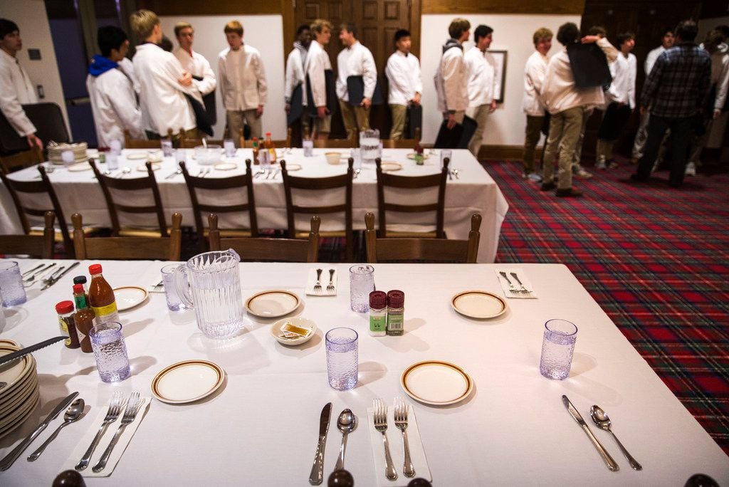 Students, who serve as waiters for meals, set the dining hall tables at Woodberry Forest...