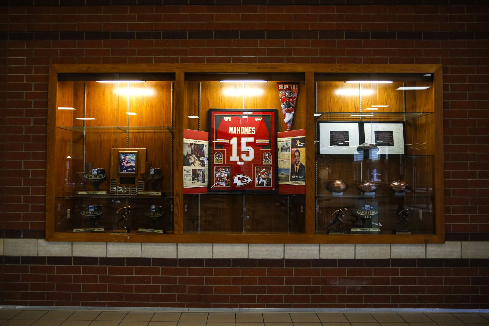 A Kansas City Chiefs jersey signed by quarterback Patrick Mahomes centerpieces the trophy...
