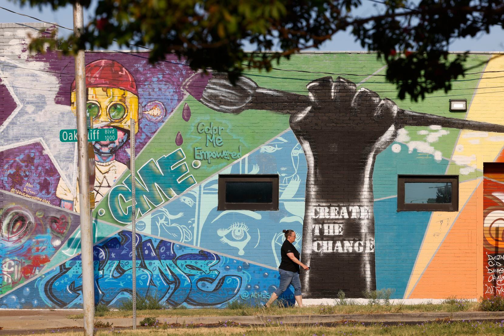A mural that reads "Create the Change” adorns a building along West Clarendon Drive in one...