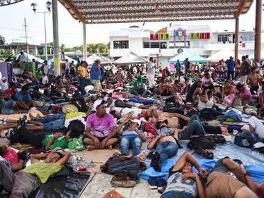 Honduran migrants, taking part in a caravan heading to the US, rest during a stop in...