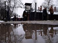 People walk next to the ''Arbeit Macht Frei" (Work Sets You Free) gate at the former Nazi...