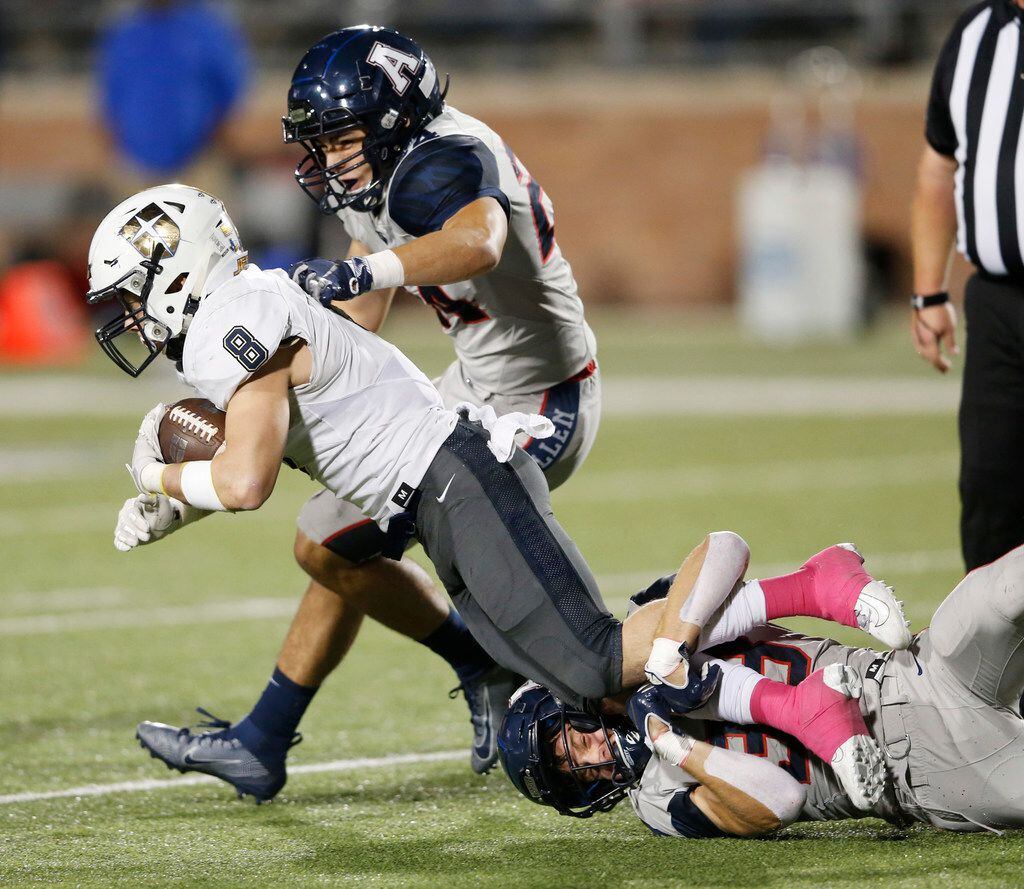 Jesuit's Jake Taylor (8) is tackled by Allen's Will Drogosch (38) and Link Smith (24) during...