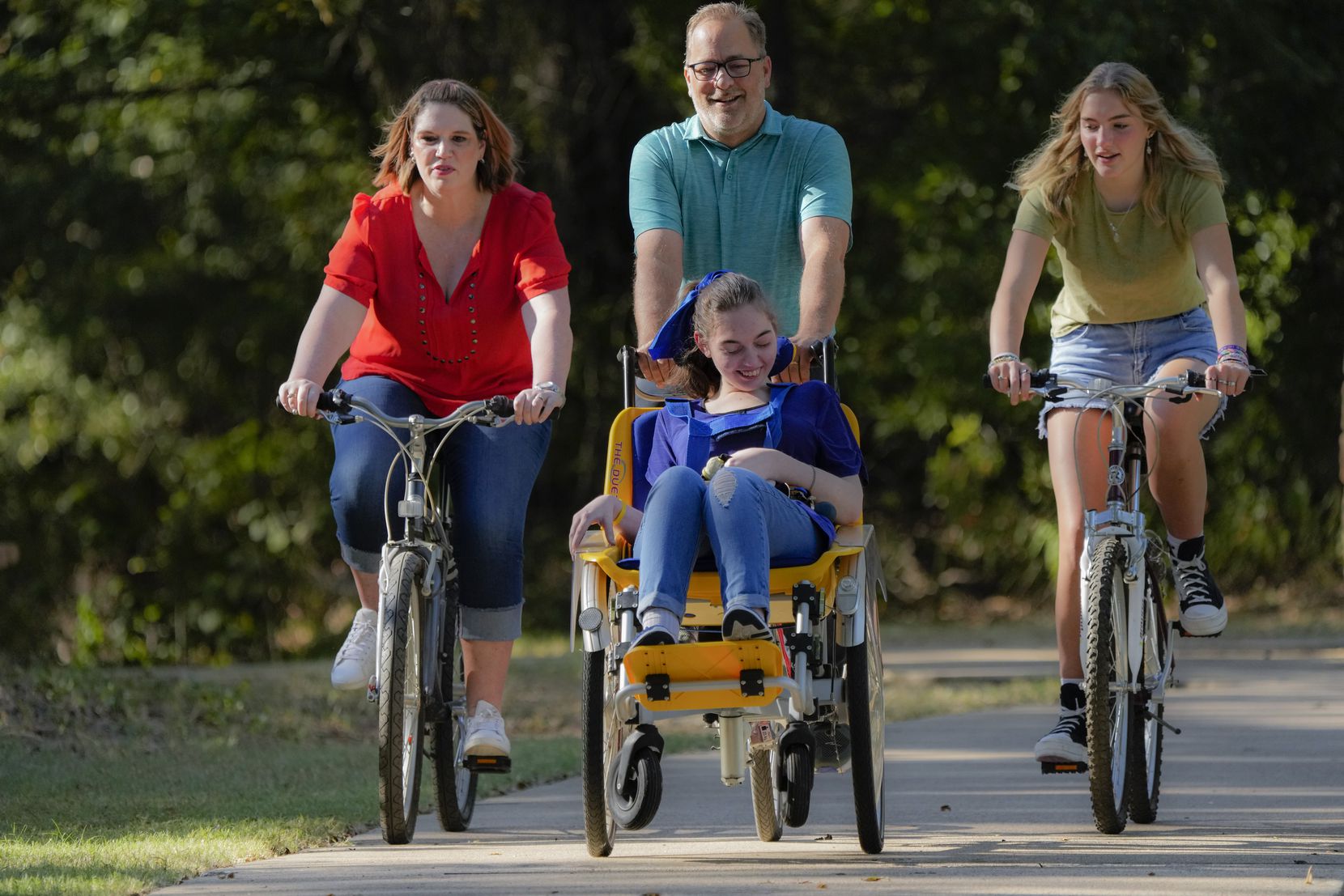 Shelby Sparks, 21, rides in a chair attached to the front of her dad's bicycle. Her father,...