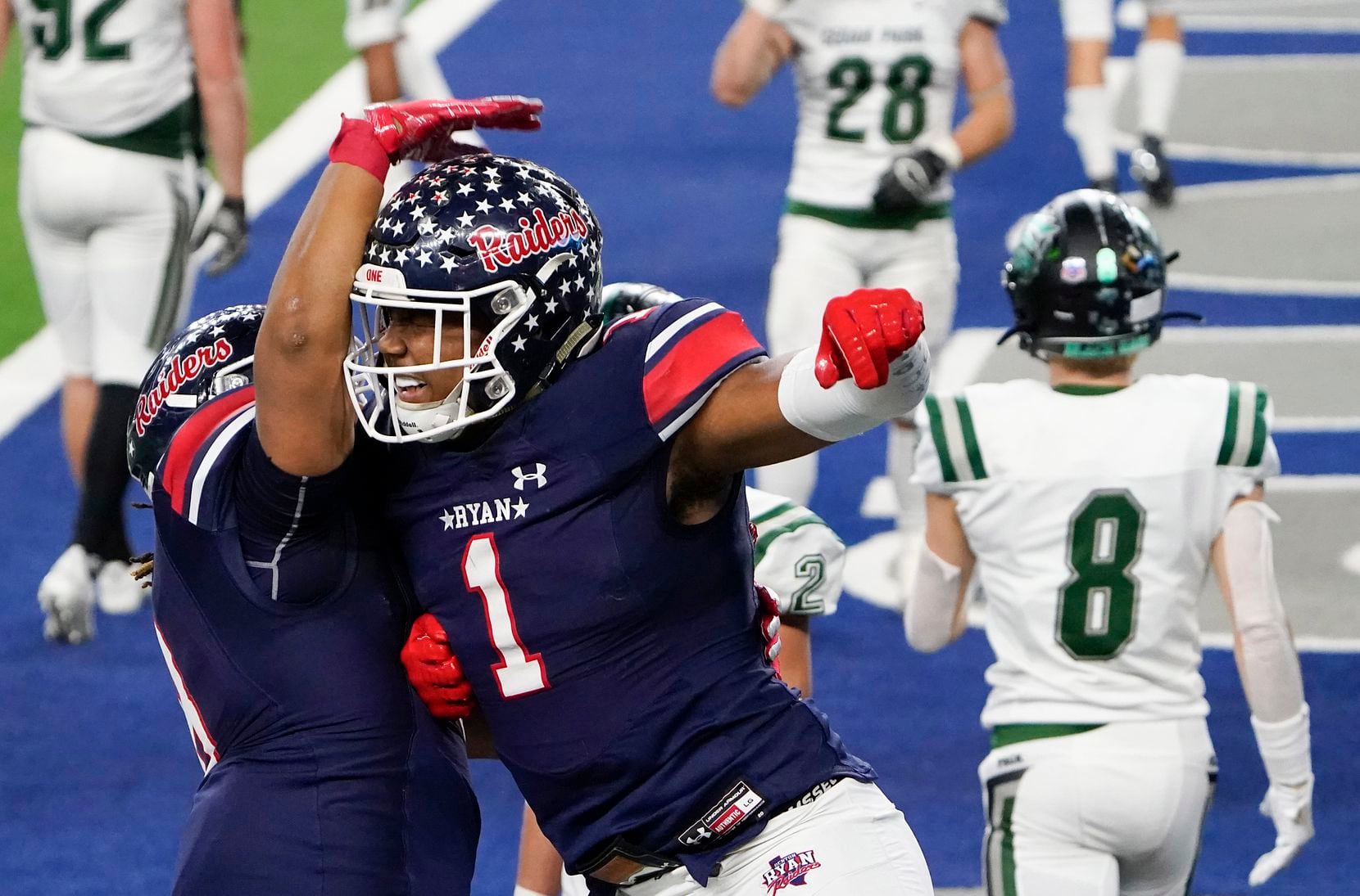 Denton Ryan wide receiver Ja'Tavion Sanders (1) celebrates with teammate Jay Sheppard (8) after catching a touchdown pass from quarterback Seth Henigan past Cedar Park defensive back Casyn Wiesenhutter (8) during the second half of the Class 5A Division I state football championship game at AT&T Stadium on Friday, Jan. 15, 2021, in Arlington, Texas. Ryan won the game 59-14. (Smiley N. Pool/The Dallas Morning News)