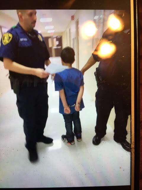 A student at Gabe P. Allen Charter School is handcuffed.