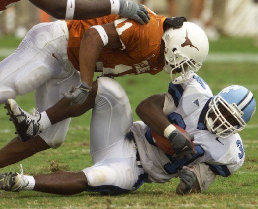ORG XMIT: S15F4FF5B (shot 08 September 2001) --- DIGITAL IMAGE --- Texas Derrick Johnson wraps up North Carolina's Andre' Williams  in the first half.  Texas defeated North Carolina 44-14