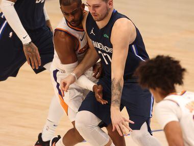 Dallas Mavericks guard Luka Doncic (77) dribbles as Phoenix Suns guard Chris Paul (3)...