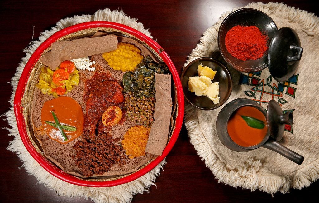 A traditional Ethiopian platter of dishes, with Doro We't in the center, served atop injera...