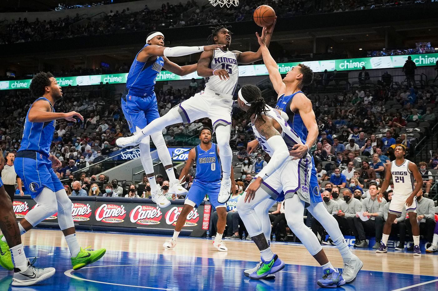 Sacramento Kings guard Davion Mitchell (15) drives to the basket between Dallas Mavericks...
