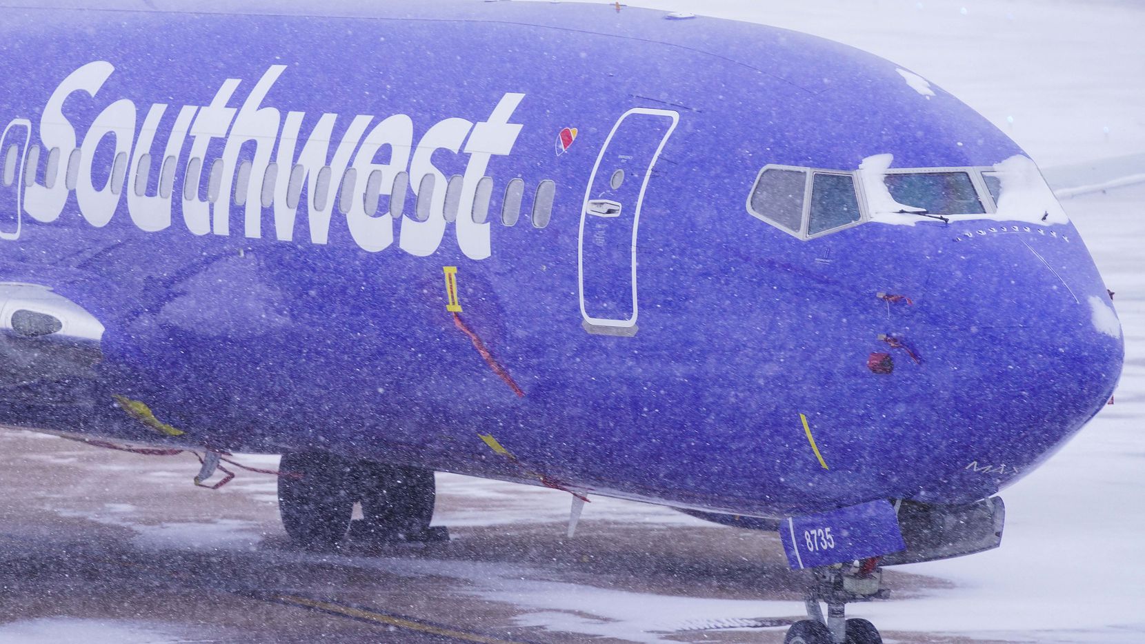 A Southwest Airlines plane sits idle in a parking area at Dallas Love Field as a winter...