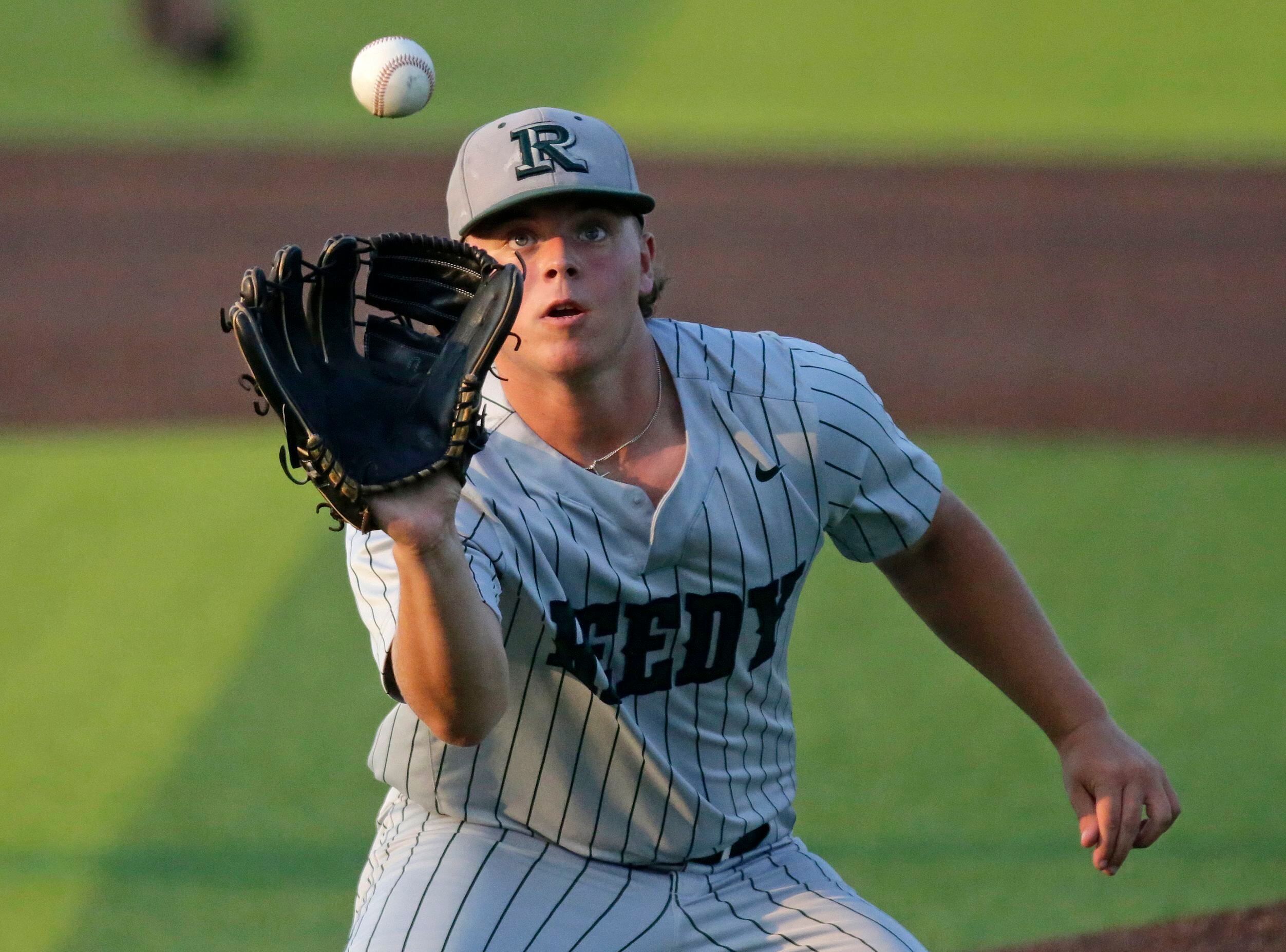 Reedy High School pitcher Kurtis Margraves (20) fields a high bounce at the mound in the...