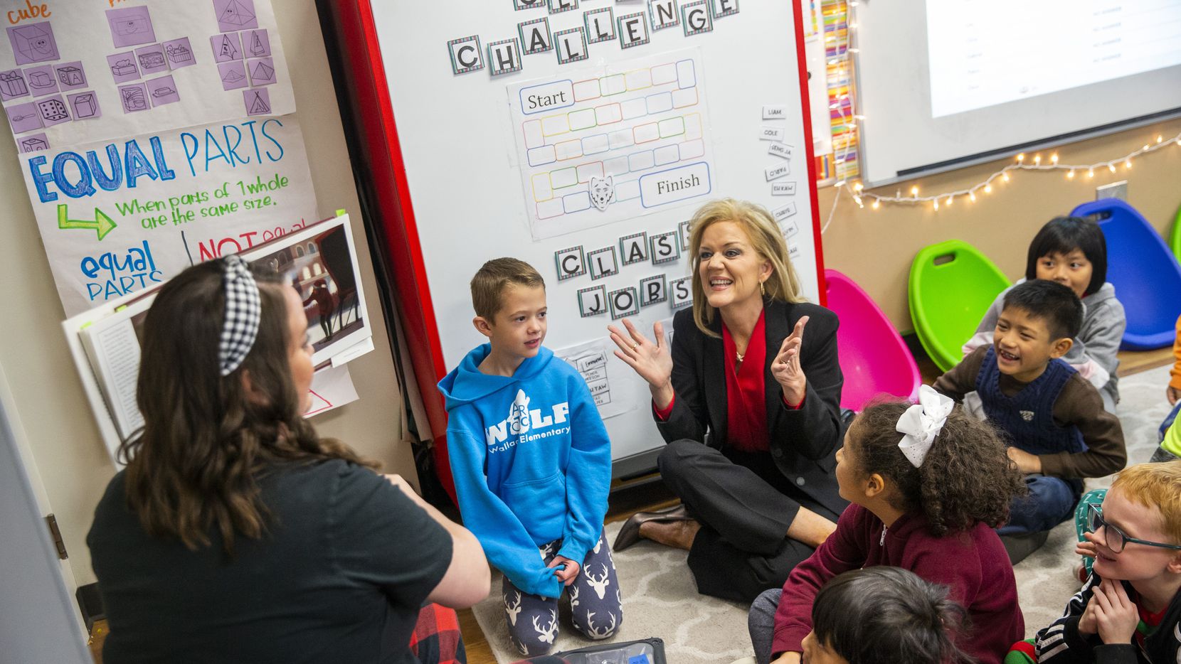 Richardson ISD Superintendent Jeannie Stone (center) reacts with students during a reading...