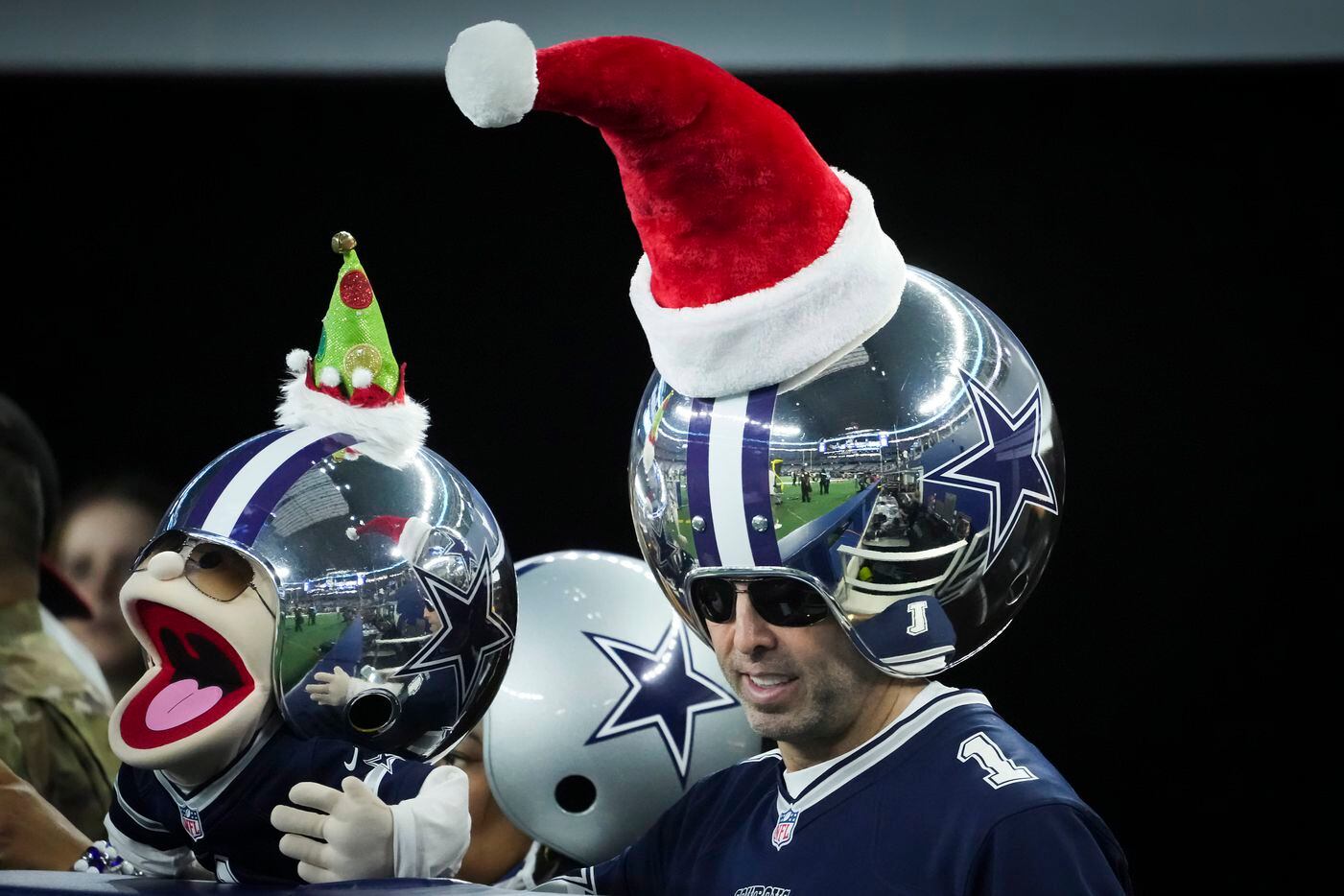 Dallas Cowboys fan Gregg Wilson wears a Santa hat atop his “Wrecking Ball” helmet before an NFL football game against the Washington Football Team at AT&T Stadium on Sunday, Dec. 26, 2021, in Arlington.