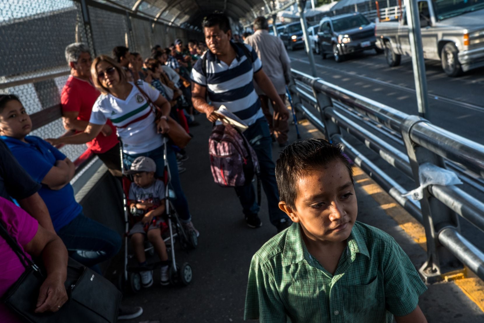 Cristopher Yovani Monjel, 7, is followed by his father, Edgar, 34, as they walk up the Paso...