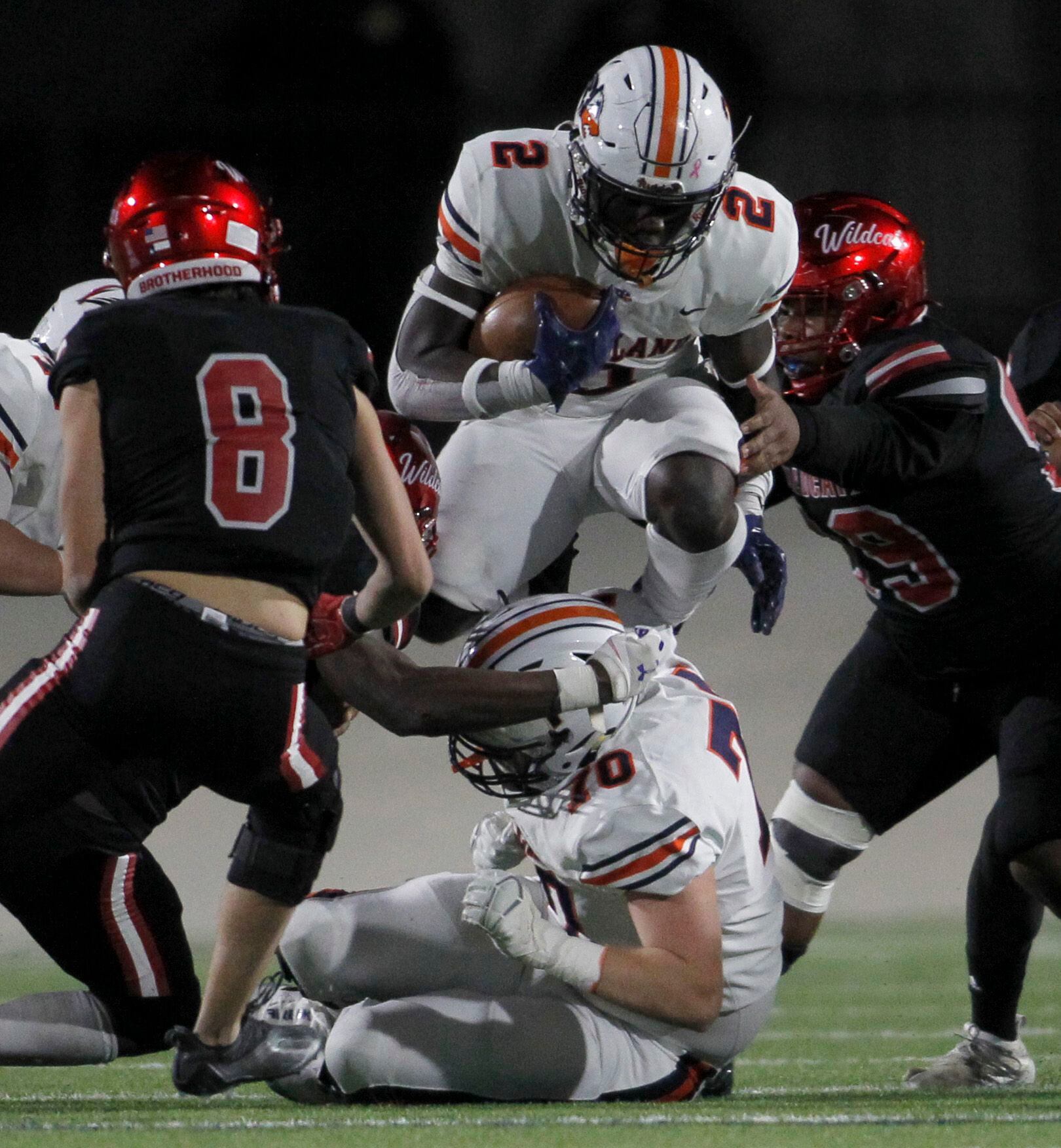 Frisco Wakeland running back Jared White (2) leaps over Wolverines offensive lineman Colton...