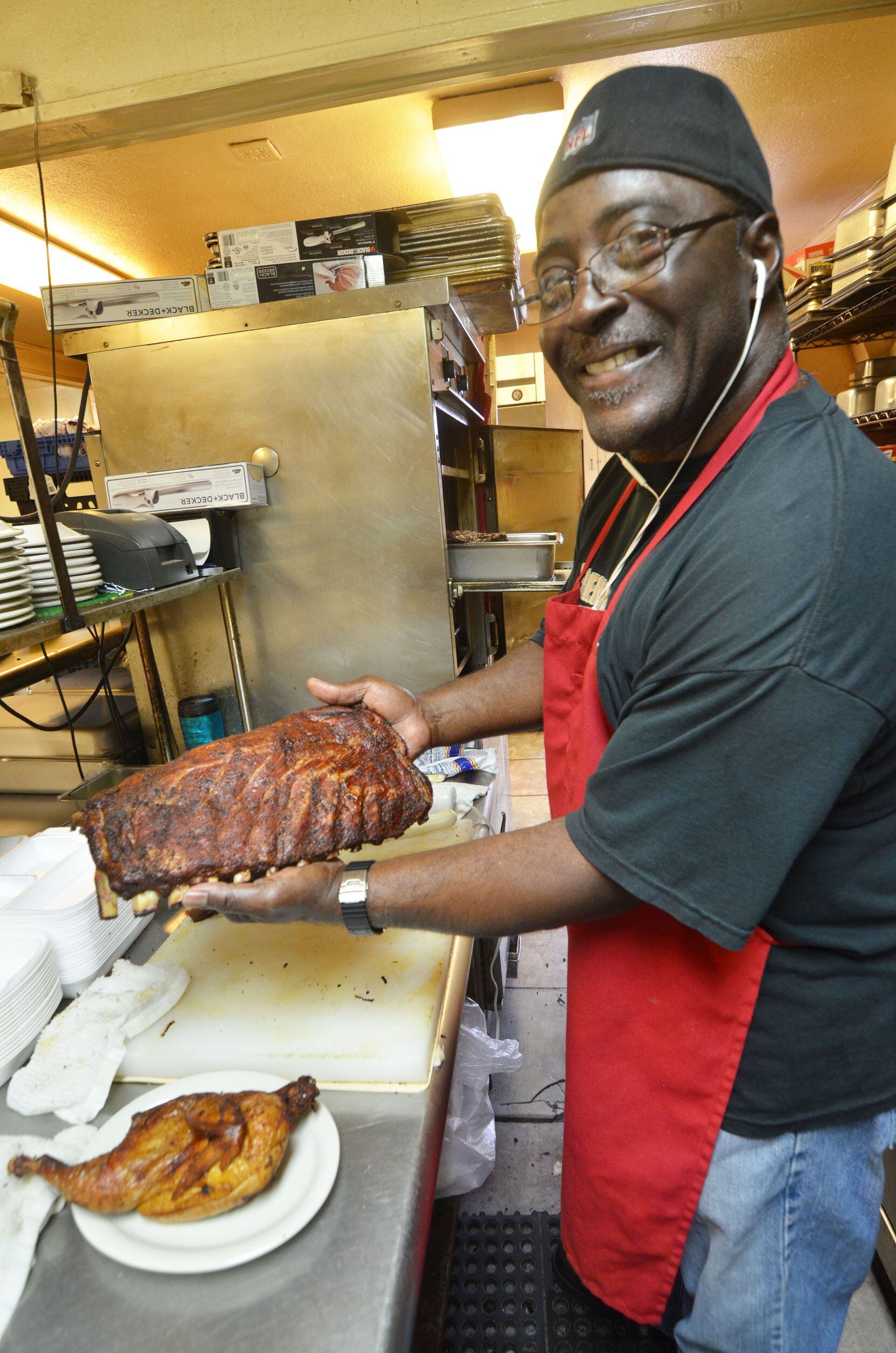Leon s relative Buster Sidney shows a rack of ribs just extracted from the smoker.  Leon s World Finest In & Out Bar-B-Que is on busy Broadway in Galveston and is a small, secret stash for filling beach barbecue baskets.  BEACHEATS