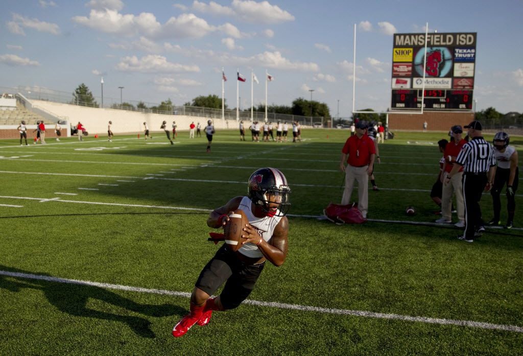 A Mansfield Legacy quarterback practices before a high school football game between Lovejoy...