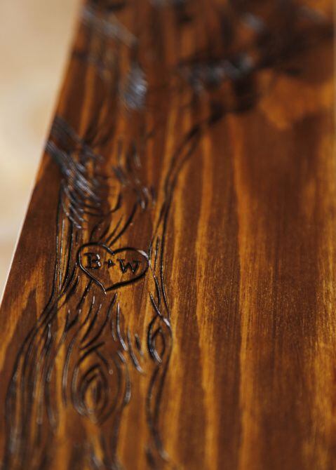 Her detailed designs are burned into the wood.