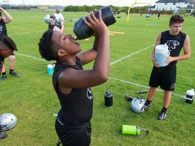 Lineman Byron Bonner stays hydrated during the first day of football practice for Frisco...