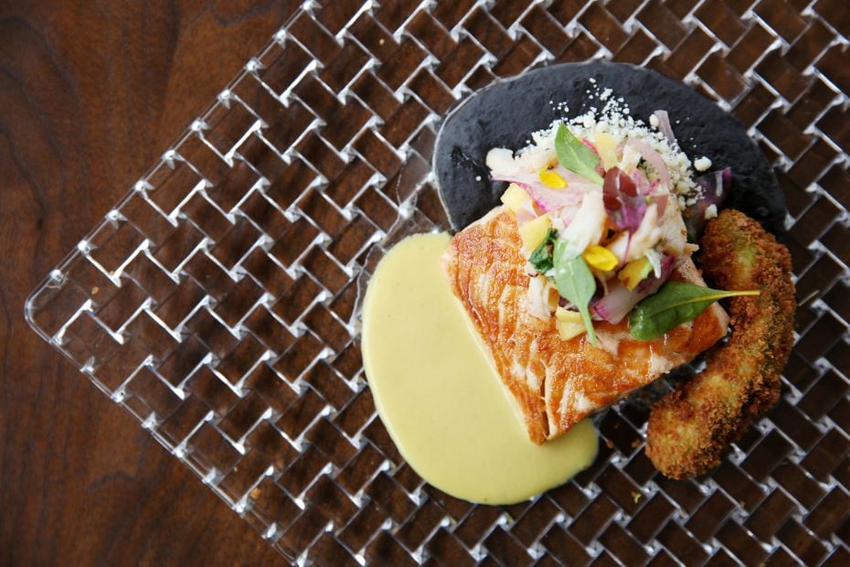 Seared king salmon with black bean-prosciutto refritos, aji-creamed-corn sauce, crab-mango ceviche and fried avocado is featured on Flora Street Cafe's lunch menu.