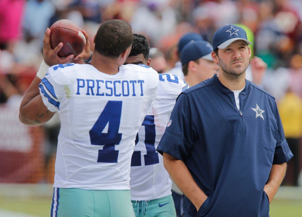 Dallas Cowboys quarterback Dak Prescott (4) and quarterback Tony Romo (9) watch from the...