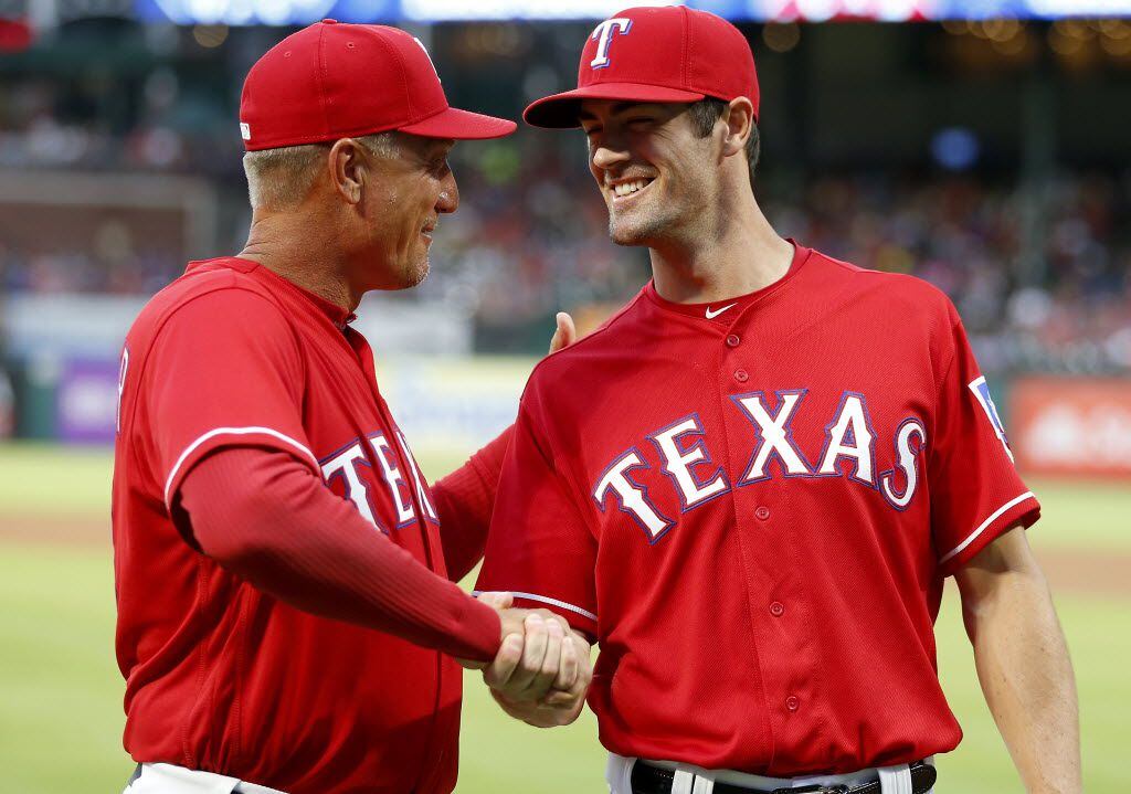 Texas Rangers starting pitcher Cole Hamels (right) shakes hands with manager Jeff Banister...