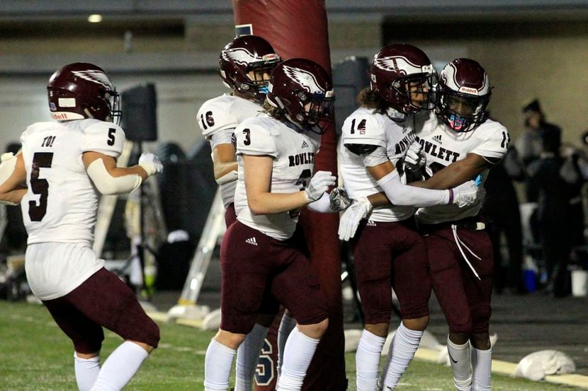 Rowlett’s Corey Kirkling (19, right) is mobbed by teammates after making a touchdown catch...