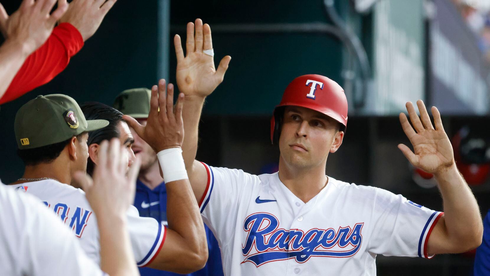 Texas Rangers Nathaniel Lowe cheers with his teammates after scoring on a passed ball during...