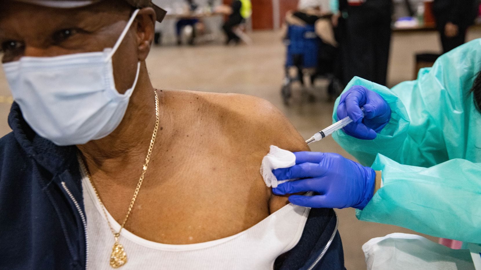 Verely Cooper, 81, of DeSoto looks away as he receives the COVID-19 vaccine at Fair Park in...
