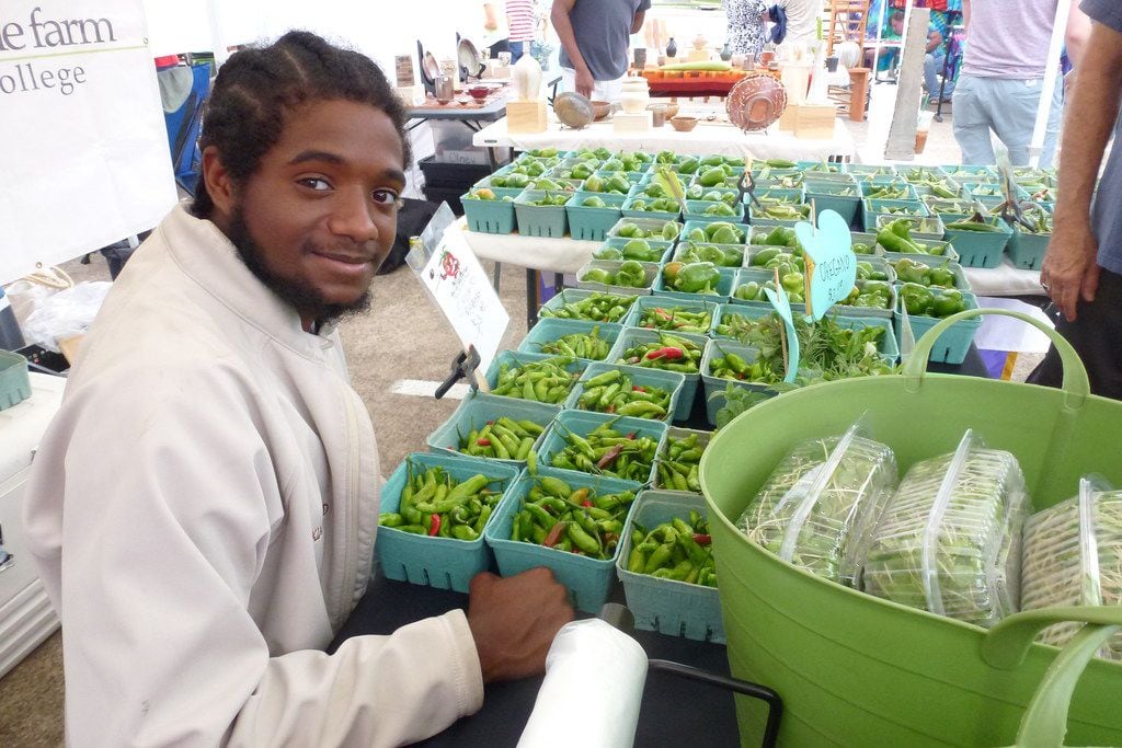 Paul Quinn College freshman Arthur McDade IV helps sell the harvest from the We Over Me Farm...