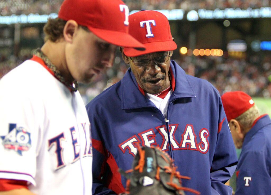 Texas manager Ron Washington talks with Derek Holland as he gets to the dugout after...